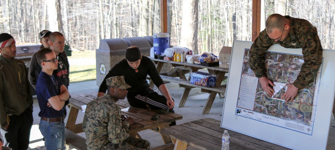 U.S. Marine Gunnery Sergeant Paul Folk teaches his poolees the proper way to use a protractor during a class on land navigation at Hogback Ridge Park February 18. The class was designed to educate the poolees on the basics of land navigation to better prepare them for recruit training at Marine Corps Recruit Depot Parris Island, South Carolina. Land navigation is taught during recruit training and is an important military skillset. (U.S. Marine Corps photo by Sgt. Stephen D. Himes/Released)