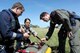 Rescue Crewman Kurt Pride, Royal Australian Air Force Base Tindal helicopter unit member, U.S. Air Force Capt. Paul Ward, 90th Fighter Squadron Flight Doctor, and Tech. Sgt. Layla Dispense, 90th FS Independent Duty Medical Technician, prepare a dummy for transport on a stretcher during helicopter rescue training at RAAF Base Tindal, Feb. 28, 2017. Ward and Dispense are deployed to Australia as part of the Enhanced Air Cooperation, a joint training and exercise initiative under the Force Posture Agreement between the U.S. and Australian governments. (U.S. Air Force photo by Staff Sgt. Alexander Martinez)