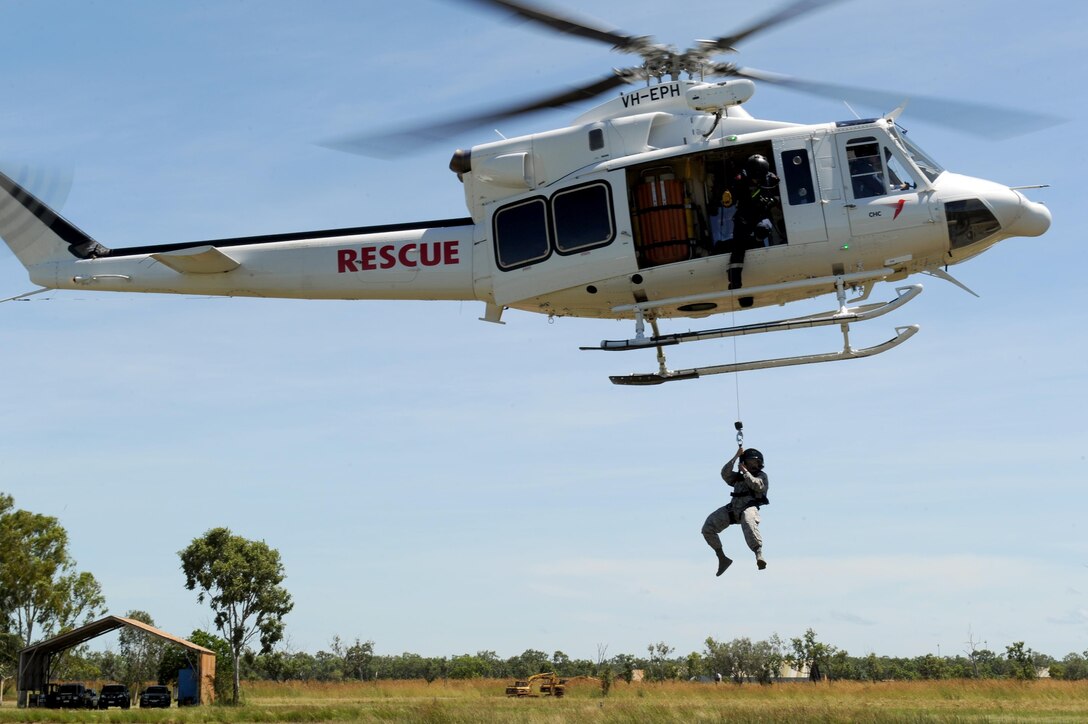 U.S. Air Force Tech. Sgt. Layla Dispense, 90th Fighter Squadron Independent Duty Medical Technician, is lowered from a helicopter by a winch during helicopter rescue training at RAAF Base Tindal, Feb. 28, 2017. Dispense is deployed to Australia as part of the Enhanced Air Cooperation, a joint training and exercise initiative under the Force Posture Agreement between the U.S. and Australian governments. (U.S. Air Force photo by Staff Sgt. Alexander Martinez)