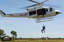 U.S. Air Force Tech. Sgt. Layla Dispense, 90th Fighter Squadron Independent Duty Medical Technician, is lowered from a helicopter by a winch during helicopter rescue training at RAAF Base Tindal, Feb. 28, 2017. Dispense is deployed to Australia as part of the Enhanced Air Cooperation, a joint training and exercise initiative under the Force Posture Agreement between the U.S. and Australian governments. (U.S. Air Force photo by Staff Sgt. Alexander Martinez)