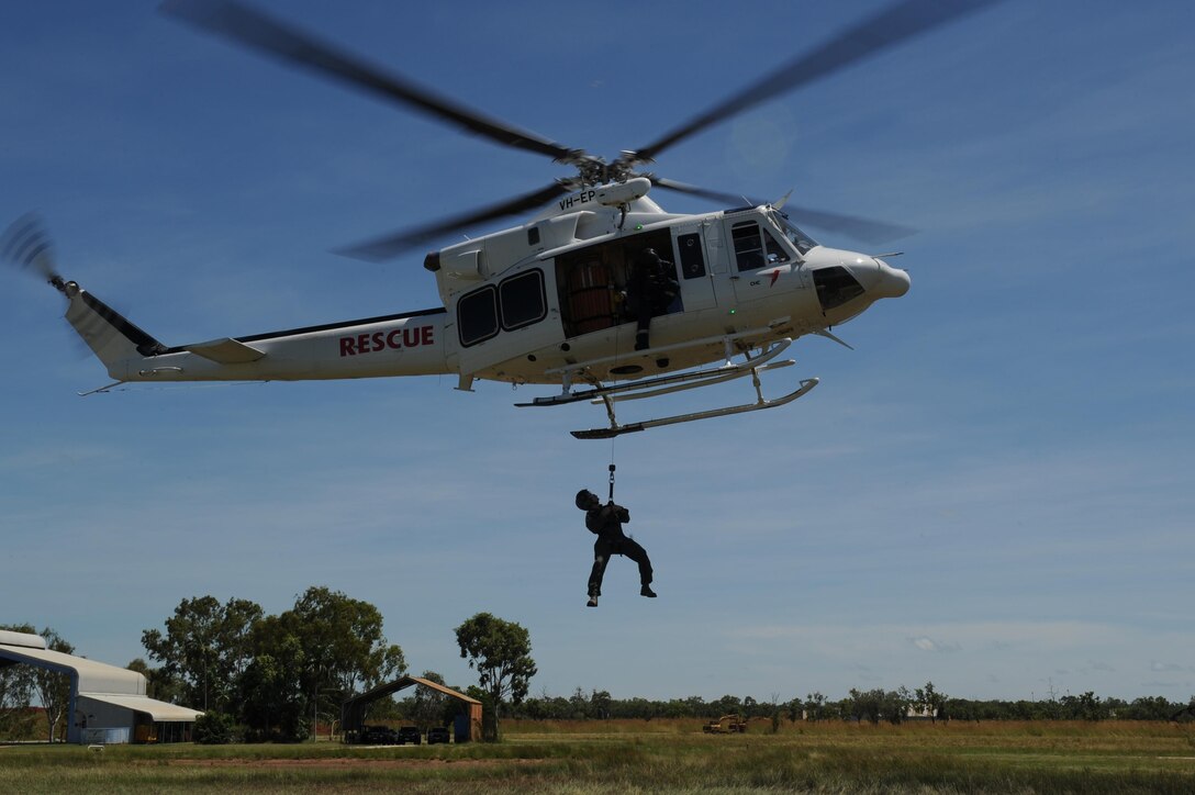 U.S. Air Force Capt. Paul Ward, 90th Fighter Squadron Flight Doctor, is raised to a helicopter by a winch during helicopter rescue training at RAAF Base Tindal, Feb. 28, 2017. Ward is deployed to Australia as part of the Enhanced Air Cooperation, a joint training and exercise initiative under the Force Posture Agreement between the U.S. and Australian governments. (U.S. Air Force photo by Staff Sgt. Alexander Martinez)