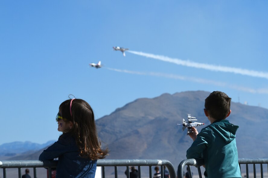 Children of Creech service members watch the U.S. Air Force Thunderbirds perform during ‘Family Day,’ March 1, 2017, at Creech Air Force Base, Nev. Family Day included demonstrations from the Thunderbirds, USO support, several Airman and Family Readiness Center functions and family-friendly amenities to support the event. (U.S. Air Force photo/Airman 1st Class James Thompson)