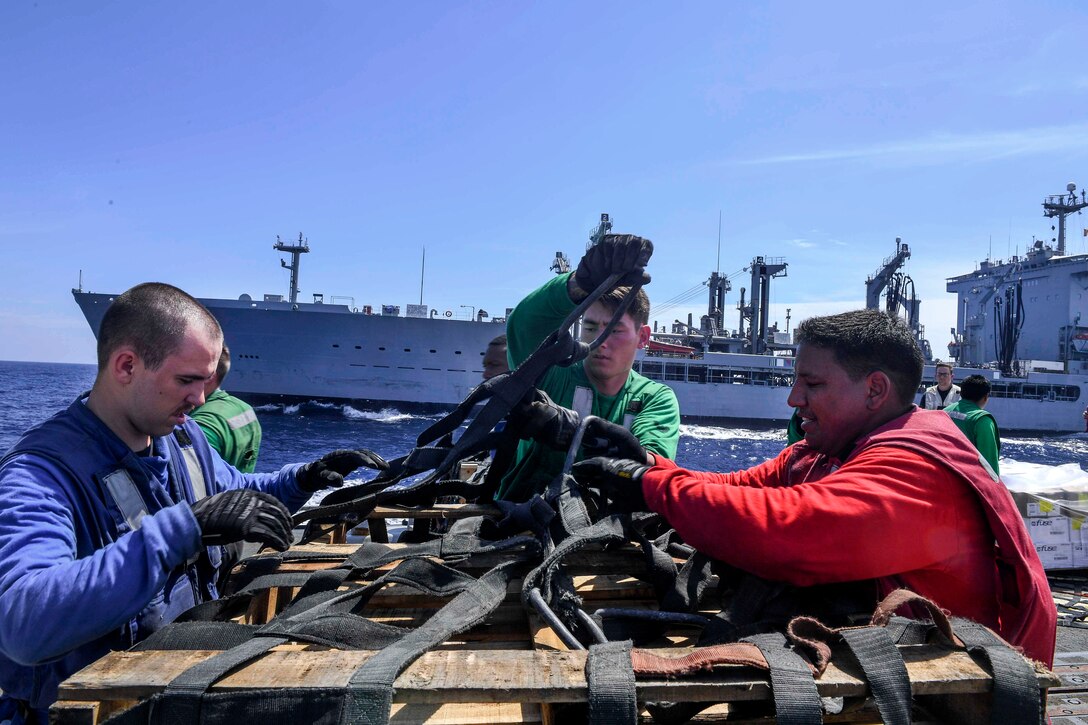 Sailors wrap a cargo net around a pallet aboard the Arleigh Burke-class guided-missile destroyer USS Wayne E. Meyer in preparation for an MH-60S Sea Hawk helicopter to pick it up during a vertical replenishment at sea in the South China Sea, Feb. 24, 2017. Navy photo by Petty Officer 3rd Class Kelsey L. Adams