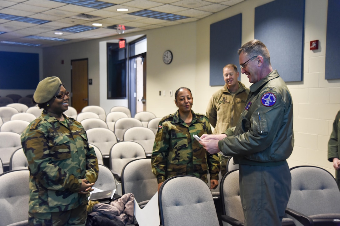 Col. Nate Alholinna, 114th Fighter Wing commander, speaks with Capt. Eria Wamenie, Suriname Army, Head of S4, and Capt. Sandra Ponit, Suriname Army, Deputy S2, Military Police, about the mission of the 114th Fighter Wing March 3, 2017 at Joe Foss Field, S.D. Female Officers of the Suriname Army visited with members of the South Dakota Air National Guard as part of a Women in Leadership Subject Matter Exchange program. (U.S. Air National Guard photo by Staff Sgt. Duane Duimstra/Released)