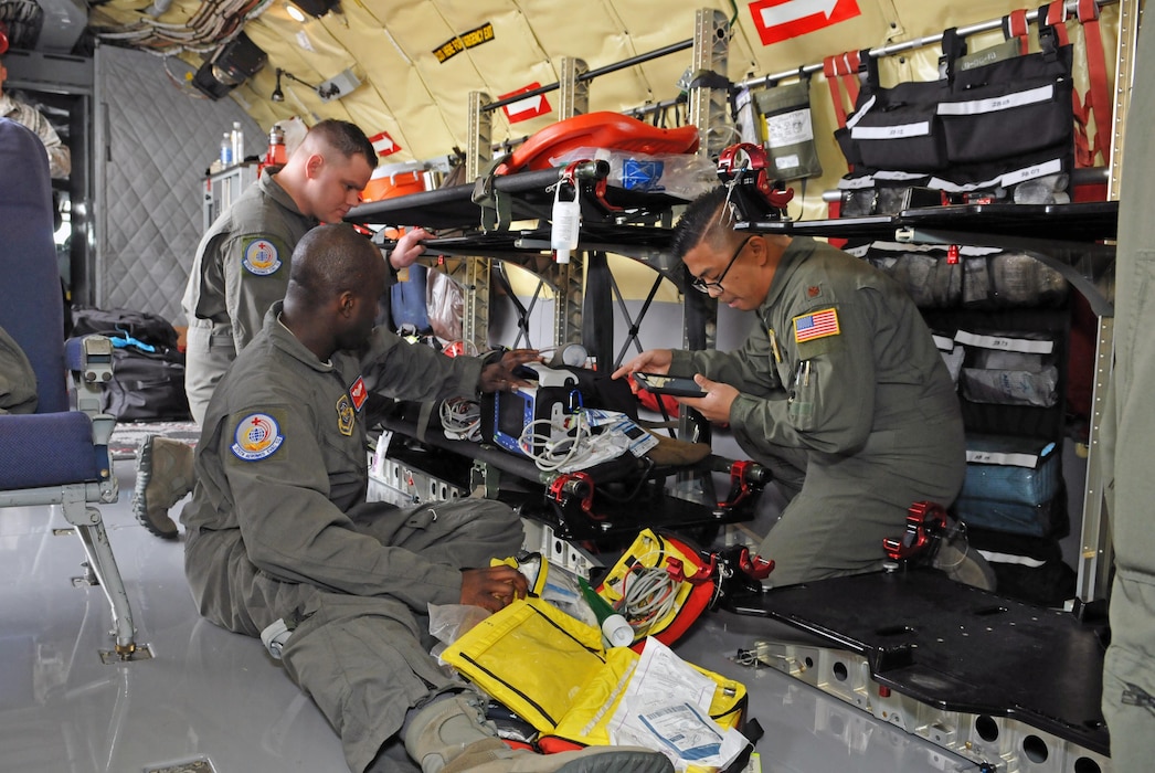 Senior Airman Kayode Idris and Maj. Joel Villavert (front), and Senior Airman Zack Tarson(back) with the 375th Aeromedical Evacuation Squadron prepare medical equipment before conducting an aeromedical evacuation mission on a KC-135R Stratotanker on Feb. 19, 2017. (U.S. Air National Guard photo by Tech. Sgt. Annie Edwards)