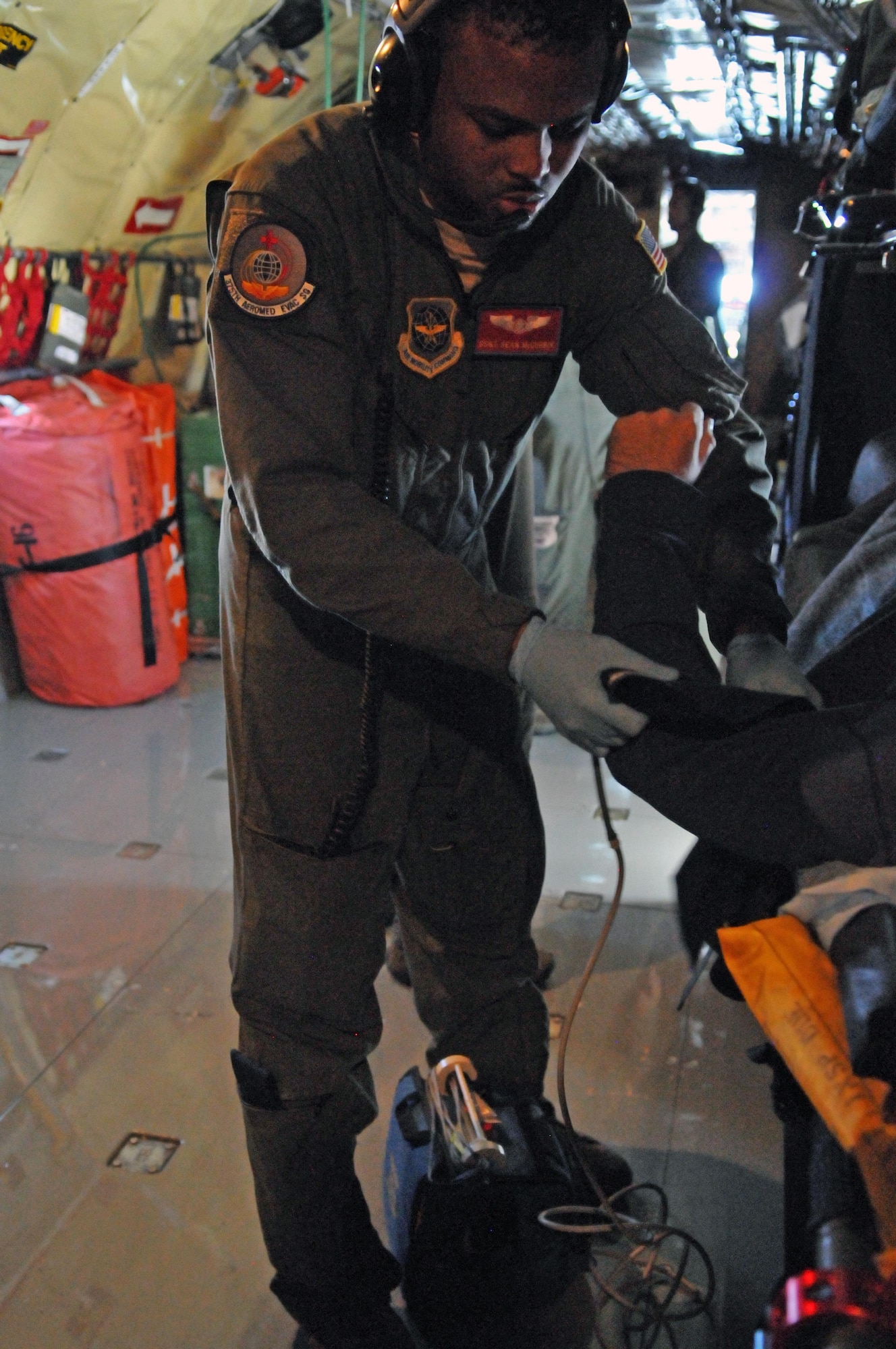 Staff Sgt. Sean McCurbin, medical technician with the 375th Aeromedical Evacuation Squadron checks a patient during an aeromedical evacuation flight returning to the U.S. from the pacific theater on Feb. 24, 2017. (U.S. Air National Guard photo by Tech Sgt. Annie Edwards)