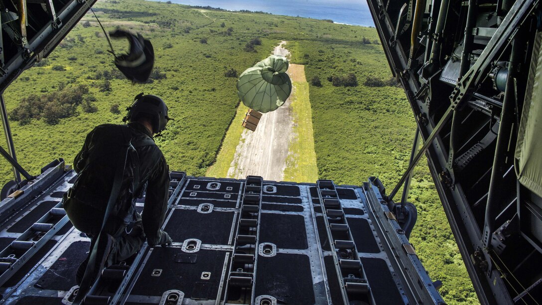 Air Force Airman 1st Class Christian Williams releases cargo from the ramp of a C-130 Hercules aircraft during exercise Cope North 2017 over Andersen Air Force Base, Guam, Feb. 24, 2017. Williams is a loadmaster assigned to the 36th Airlift Squadron. Air Force photo by Senior Airman Keith James