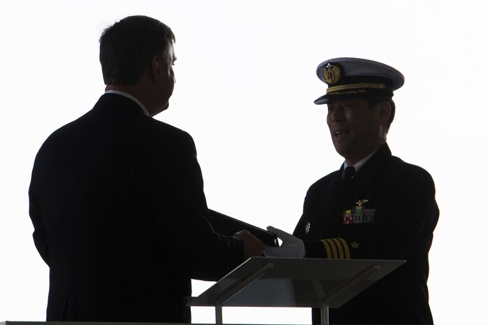 A representative for Sikorsky, left, receives a token of appreciation from Japan Maritime Self-Defense Force Capt. Motoi Haga, right, commanding officer of Mine Countermeasures Helicopter Squadron 111 (HM-111), during a retirement ceremony to decommission the last two remaining active MH-53E helicopters from service at Marine Corps Air Station Iwakuni, Japan, March 3, 2017. The MH-53E’s flew 6,000 hours throughout 27 years as airborne mine countermeasures and heavy transport helicopters for HM-111. (U.S. Marine Corps photo by Lance Cpl. Joseph Abrego)