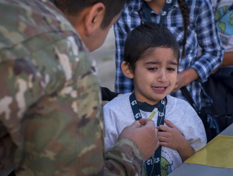 A new 919th Special Operations Wing deployer doesn’t want to receive his “vaccination” prior to their mission during the Operation Hero event at Duke Field, Fla., March 4.  The wing held a mock deployment for the Reserve children to include a deployment line, simulated flight and a “down range” location with games and displays.  (U.S. Air Force photo/Samuel King Jr.)