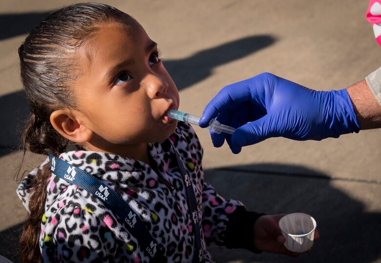 A new 919th Special Operations Wing deployer accepts her “vaccination” prior to their mission during the Operation Hero event at Duke Field, Fla., March 4.  The wing held a mock deployment for the Reserve children to include a deployment line, simulated flight and a “down range” location with games and displays.  (U.S. Air Force photo/Samuel King Jr.)