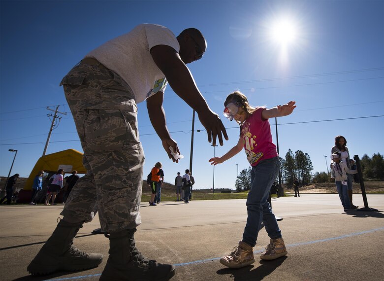 A new 919th Special Operations Wing deployer tries to walk a straight line wearing “drunk goggles” during the Operation Hero event at Duke Field, Fla., March 4.  The wing held a mock deployment for the Reserve children to include a deployment line, simulated flight and a “down range” location with games and displays.  (U.S. Air Force photo/Samuel King Jr.)