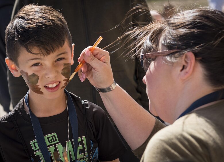 A new 919th Special Operations Wing deployer dons his war paint before a mission during the Operation Hero event at Duke Field, Fla., March 4.  The wing held a mock deployment for the Reserve children to include a deployment line, simulated flight and a “down range” location with games and displays.  (U.S. Air Force photo/Samuel King Jr.)