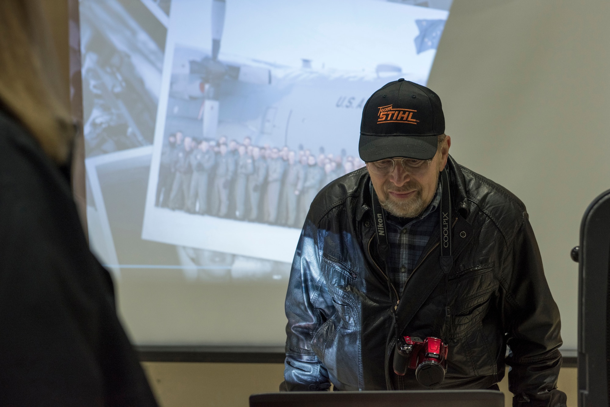 JOINT BASE ELMENDORF-RICHARDSON, Alaska -- Retired Chief Master Sgt. Robert Paulson, a former C-130 loadmaster, reminisces as he watches a unit slide show here March 4, 2017, during a ceremony marking the fly-away of the Alaska Air National Guard's last two C-130 Hercules aircraft. After 41 years of flying the C-130 aircraft, the 144th Airlift Squadron’s 12 C-130s were divested, with the planes either being transferred to outside units or retired from service. The unit’s last two aircraft departed the base the following day. (U.S. Air National Guard photo by Tech. Sgt. N. Alicia Halla/Released)