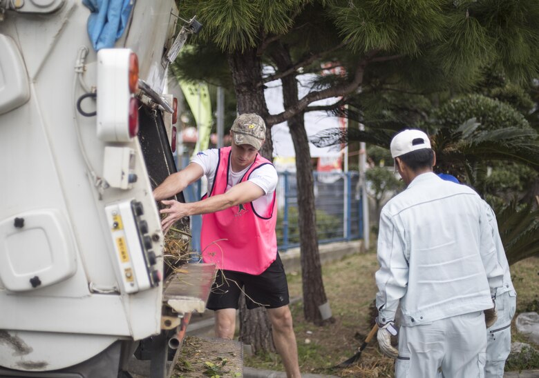 U.S. Air Force Senior Airman Marcus Lollis, 909th Aircraft Maintenance Unit integrated flight control systems journeyman, helps dispose of landscaping debris from a volunteer event at Yara Elementary School March 5, 2017, at Kadena Town, Japan. Airmen from the 909th AMU volunteer often in Kadena Town to give back to the local community. (U.S. Air Force photo by Senior Airman Omari Bernard/Released)