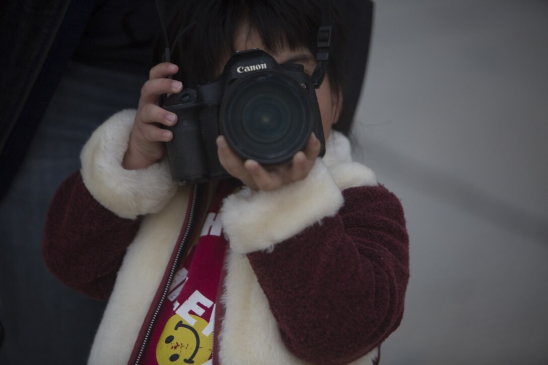 An Okinawan child pretends to be a photographer on a playground during a community outreach event, March 3, 2017, at Yugafu Church, Okinawa, Japan. Marines and Sailors with 3D Marine Expeditionary Brigade provided food for less fortunate children during the event. This was the second time 3D MEB Marines and Sailors have participated in what will become a quarterly event. During the first, a Thanksgiving dinner, 3D MEB Marines and Sailors provided food for a total of 100 people at the church. (U.S. Marine Corps photo by Lance Cpl. Jonah Baase) 