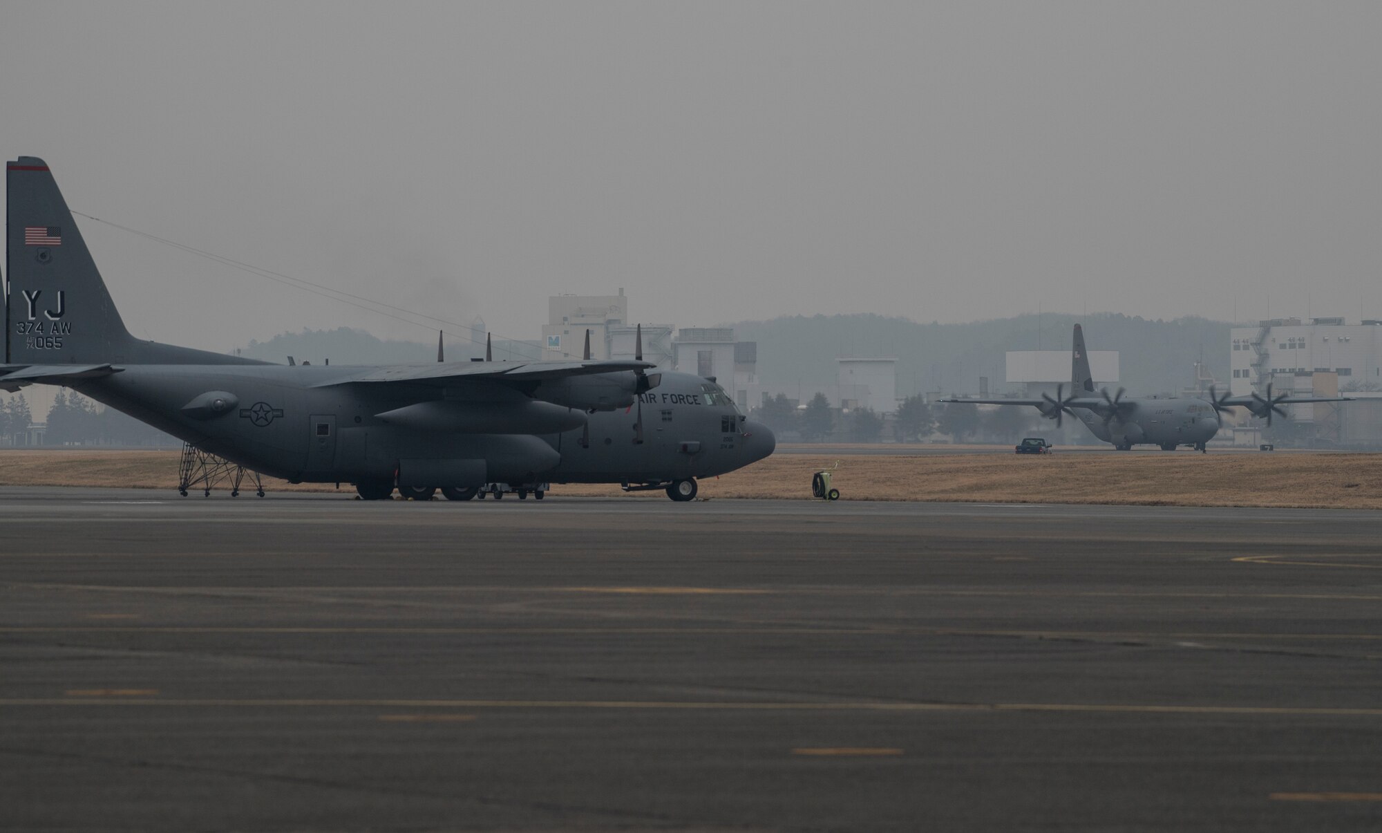 A C-130J Super Hercules with the 36th Airlift Squadron, right, taxis down the runway at Yokota Air Base, Japan, March 6, 2016. The new aircraft will eventually replace the unit’s existing C-130H fleet, which has been in service for nearly 30 years. (U.S. Air Force photo by Staff Sgt. David Owsianka)