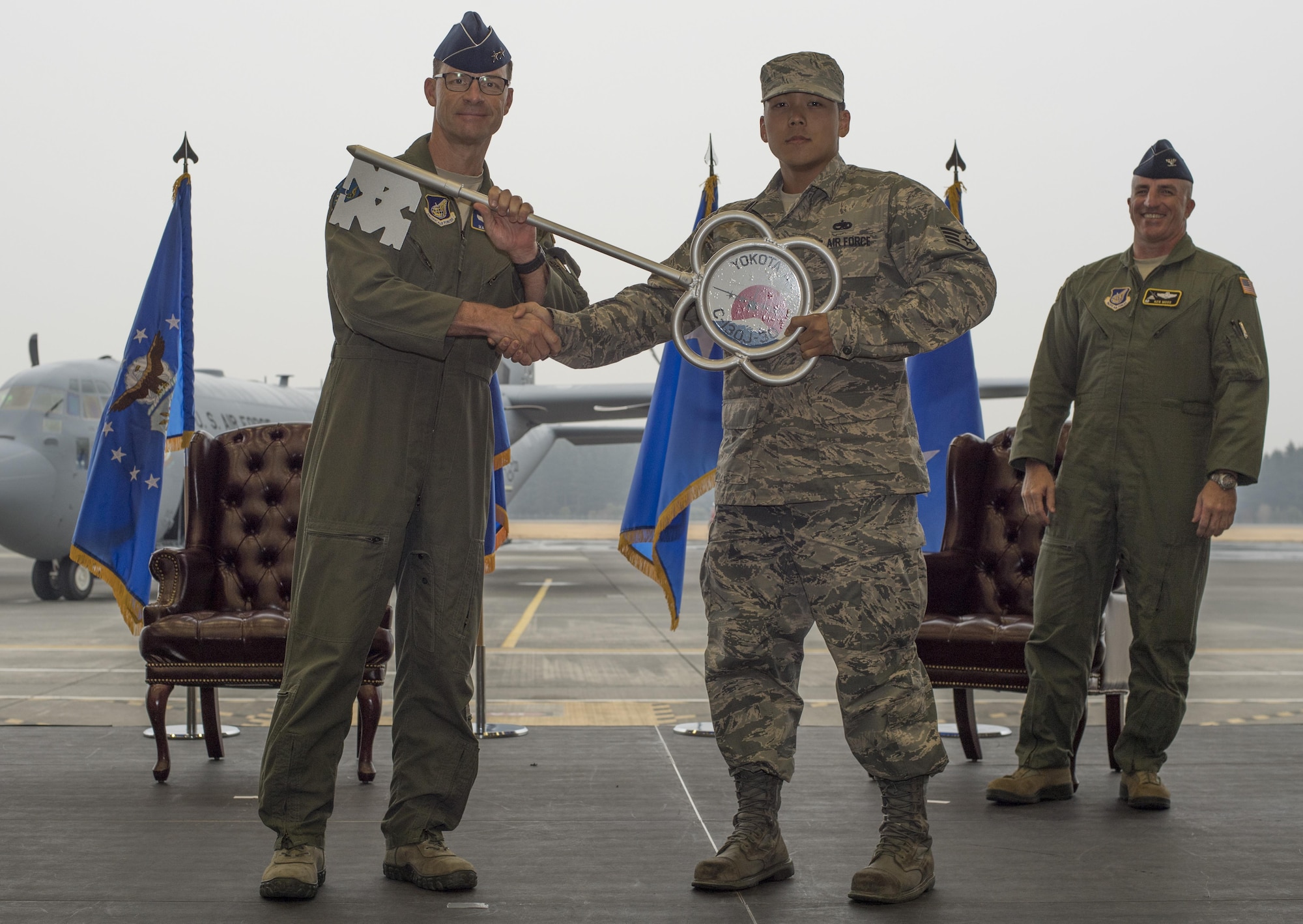 Maj. Gen. Mark Dillon, Pacific Air Forces vice commander, hands a ceremonial key to Staff Sgt. Gene Phonthipsavath, 374th Aircraft Maintenance Squadron dedicated crew chief, during a C-130J Super Hercules arrival ceremony at Yokota Air Base, Japan, March 6, 2016. Compared to older C-130s, the J model climbs faster and higher, flies farther at a higher cruise speed, and takes off and lands in a shorter distance. (U.S. Air Force photo by Staff Sgt. David Owsianka)