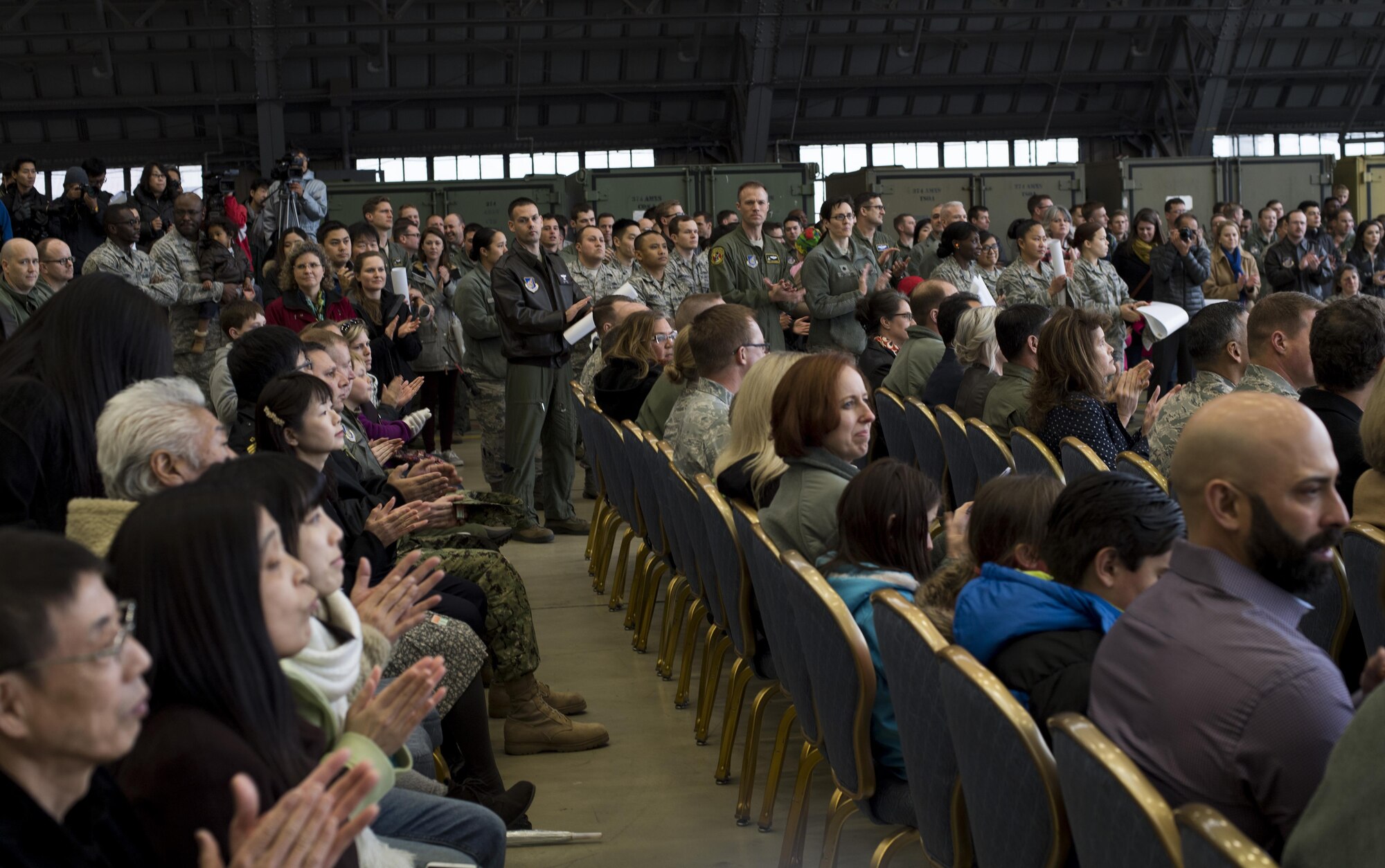 Ceremony attendees clap during a C-130J Super Hercules arrival ceremony at Yokota Air Base, Japan, March 6, 2016. Much like its H-model older brother, the C-130J will be used to support critical peacekeeping and contingency operations in the Indo-Asia Pacific region, including cargo delivery, troop transport, airdrop and aeromedical missions. (U.S. Air Force photo by Staff Sgt. David Owsianka)