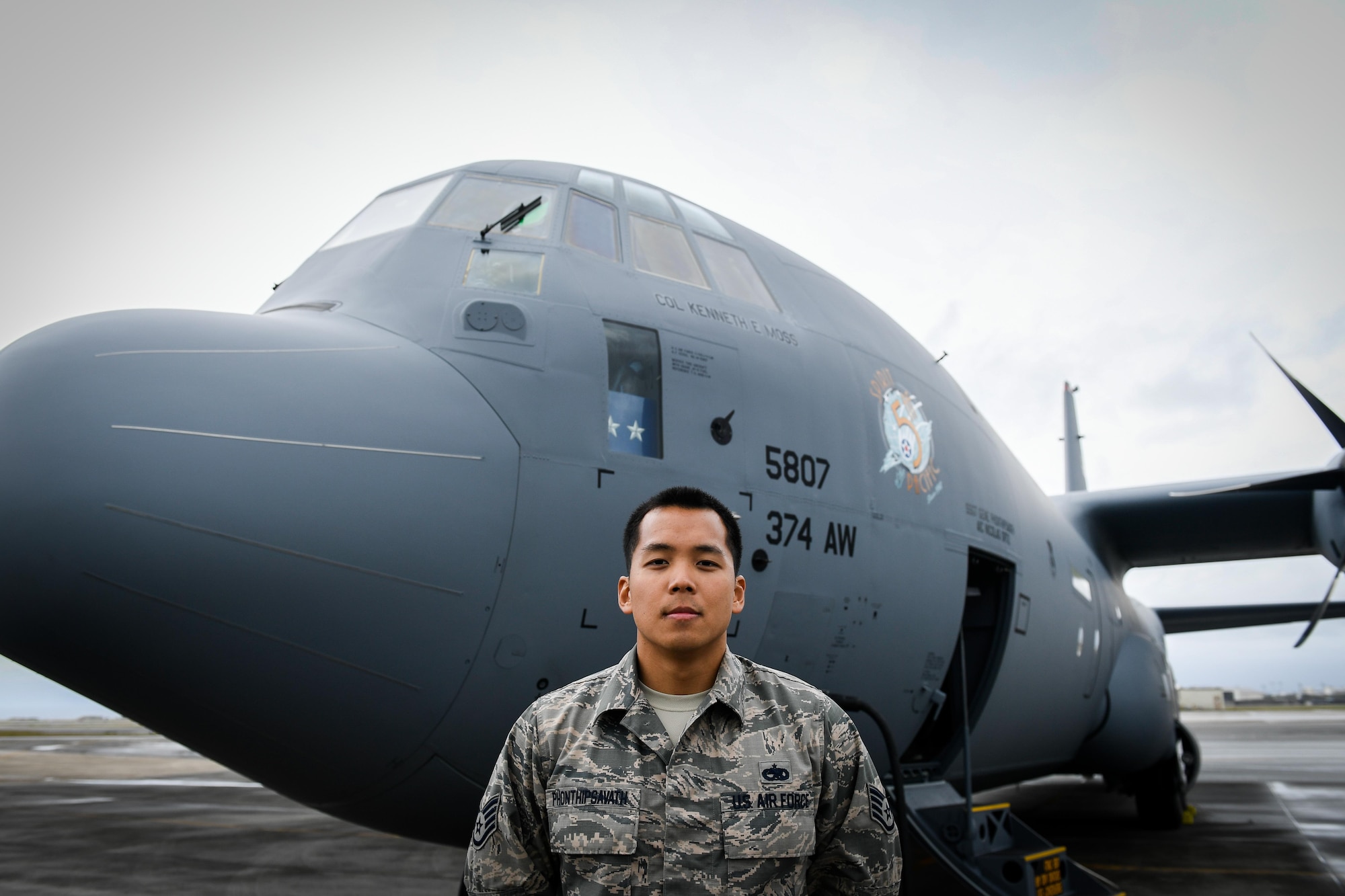 Staff Sgt. Gene Phonthipsavath, 374th Aircraft Maintenance Squadron dedicated crew chief,  poses for a photo in front of a C-130J Super Hercules at Kadena Air Base, Japan, March 6, 2017. This is the first C-130J to be assigned to Pacific Air Forces. Yokota serves as the primary Western Pacific airlift hub for U.S. Air Force peacetime and contingency operations. Missions include tactical air land, airdrop, aeromedical evacuation, special operations and distinguished visitor airlift. (U.S. Air Force photo by Staff Sgt. Michael Smith)
