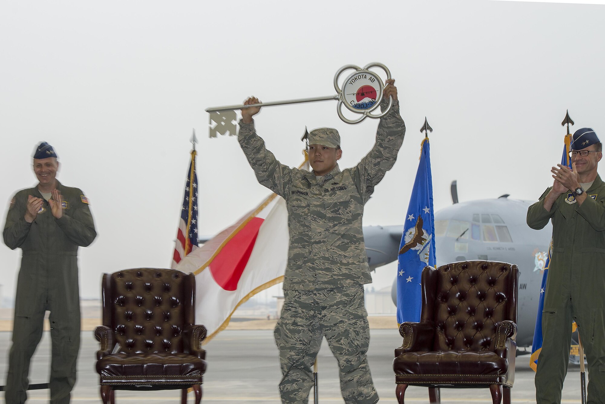 Staff Sgt. Gene Phonthipsavath, 374th Aircraft Maintenance Squadron dedicated crew chief, holds aloft the ceremonial key during a ceremony held to celebrate the arrival of the first C-130J Super Hercules assigned to Yokota Air Base, Japan, Mar. 6, 2017. The new aircraft is scheduled to have fully replaced the 374th Airlift Wing's C-130 Hercules fleet by 2018. (U.S. Air Force photo by Senior Airman David C. Danford)