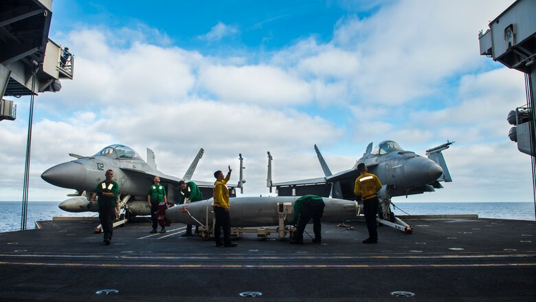 U.S. Navy Sailors position aircraft and fuel cells on the aircraft carrier USS Carl Vinson (CVN 70) hangar bay elevator for transport to the flight deck, Nov. 7, 2016, on the Pacific Ocean. The Carl Vinson Strike Group conducted Composite Training Unit Exercise in preparation for an upcoming deployment. (U.S. Navy Photo by Seaman Daniel P. Jackson Norgart/Released)