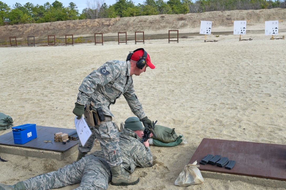 New Jersey Air National Guard Tech. Sgt. William Lonzson, standing, hands an airman a magazine for the next round of firing during range qualification at Joint Base McGuire-Dix-Lakehurst, New Jersey, Feb. 26, 2017. Lonzson is a combat arms instructor assigned to the 108th Security Forces Squadron. Air National Guard photo by Staff Sgt. Ross A. Whitley