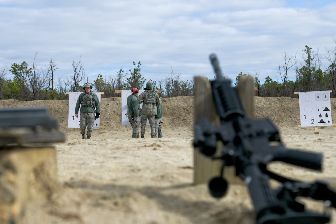 New Jersey Air National Guard Airman 1st Class Nicholas Mazza, left, returns from reviewing his target during range qualification at Joint Base McGuire-Dix-Lakehurst, New Jersey, Feb. 26, 2017. Mazza is assigned to the assigned to the 108th Security Forces Squadron. New Jersey Air National Guard photo by Staff Sgt. Ross A. Whitley