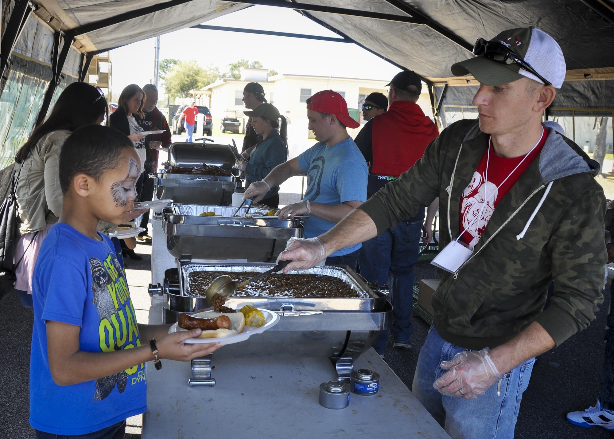 A volunteer serves up some beans to a 919th Special Operations Wing family member during the unit’s annual Wing Day March 4 at Duke Field, Fla.  The wing sets aside a special day each year to show appreciation for its reservists and their family members. Events included music, food, children’s games, etc. (U.S. Air Force photo/Dan Neely)