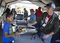 A volunteer serves up some beans to a 919th Special Operations Wing family member during the unit’s annual Wing Day March 4 at Duke Field, Fla.  The wing sets aside a special day each year to show appreciation for its reservists and their family members. Events included music, food, children’s games, etc. (U.S. Air Force photo/Dan Neely)