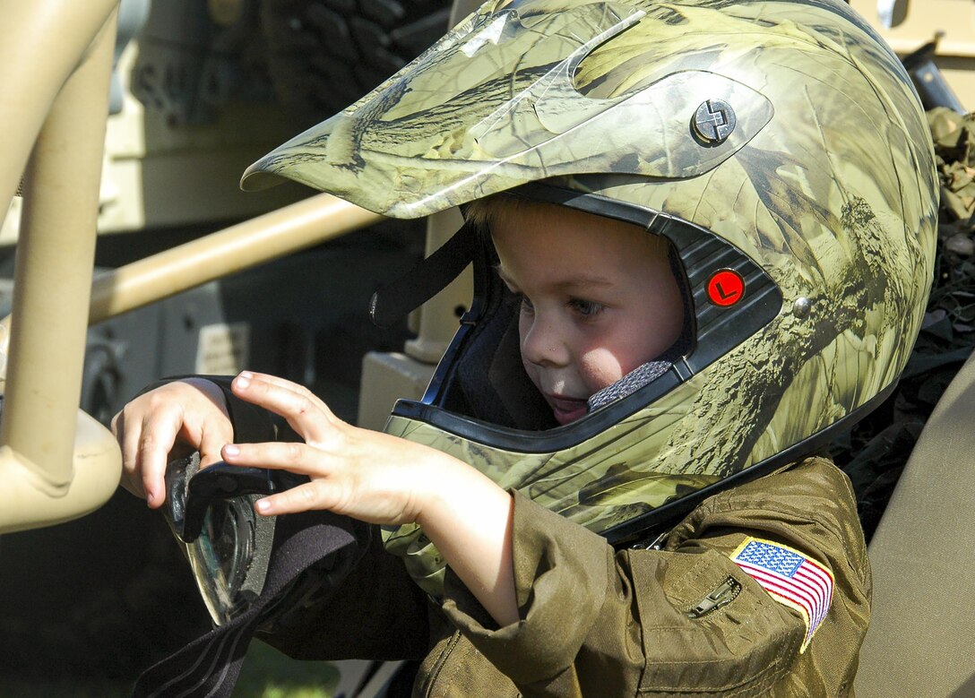 A recent “Operation Hero” deployer dons a helmet while sitting in a security forces all-terrain vehicle during the 919th Special Operations Wing’s annual Wing Day March 4 at Duke Field, Fla.  The wing sets aside a special day each year to show appreciation for its reservists and their family members. Events included music, food, children’s games, etc. (U.S. Air Force photo/1st Lt. Monique Roux)