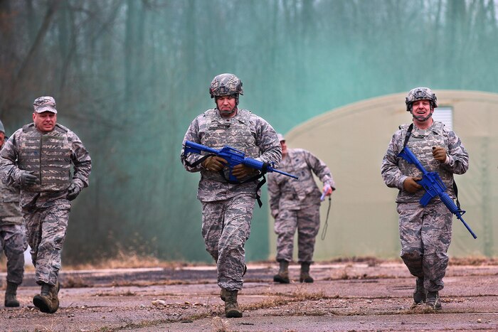As green smoke billows in the background from a smoke grenade during an exercise scenario as the 445th Security Forces Squadron participates in ‘Winter Challenge’ here Feb. 12, 2017. The challenge is designed to provide an experience during inclement weather. The event consisted of several stages to include: vehicle inspections, ammo carries, MOUT (military operations in urban terrain), rolling a large tire and pushing a Humvee more than 200 feet.  (U.S. Air Force photo /Tech. Sgt. Patrick O’Reilly)