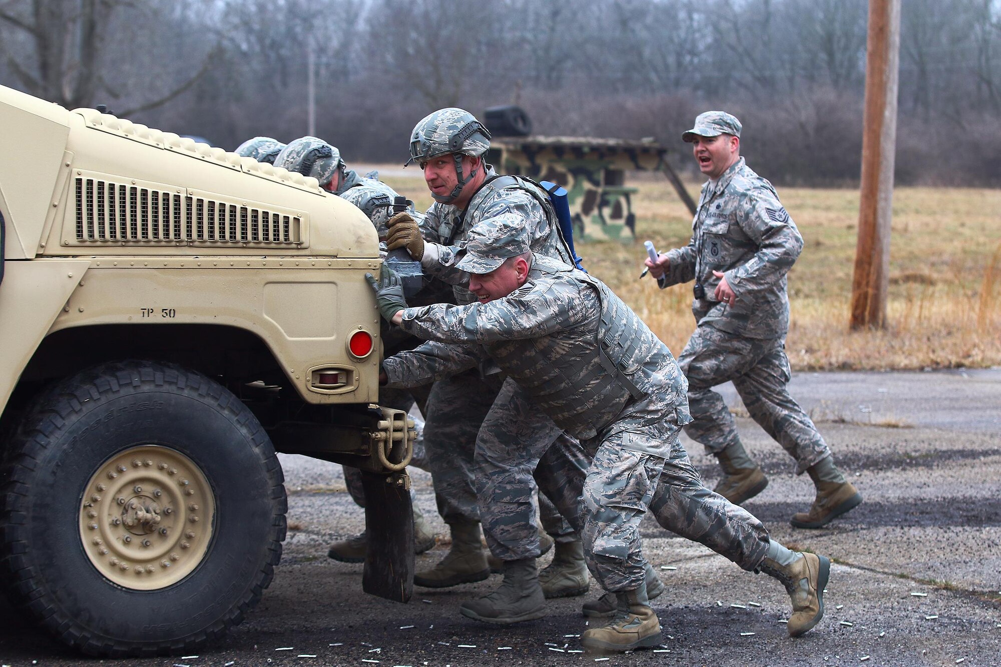 Airmen from the 445th Security Forces Squadron push a Humvee as one of the events that was part of ‘Winter Challenge’ here Feb. 12, 2017. 'Winter Challenge' is designed to provide an experience during inclement weather. The event consisted of several stages to include: vehicle inspections, ammo carries, MOUT (military operations in urban terrain), rolling a large tire and pushing a Humvee more than 200 feet.  (U.S. Air Force photo /Tech. Sgt. Patrick O’Reilly)