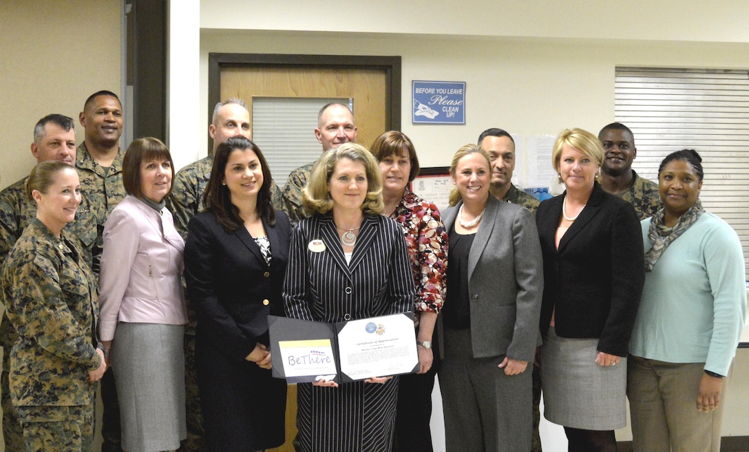Mary Jo Betyak-Eisler holds the Outreach Recognition Award for the work the Community Counseling Program did on Marine Corps Base Quantico during September's Suicide Prevention Month. Surrounding her are various department heads from Headquarters Marine Corps, Marine Corps Base Quantico, the Department of Defense Suicide Prevention Office and Col. Joseph Murray, commander, Marine Corps Installations-National Capital Region, Marine Corps Base Quantico.