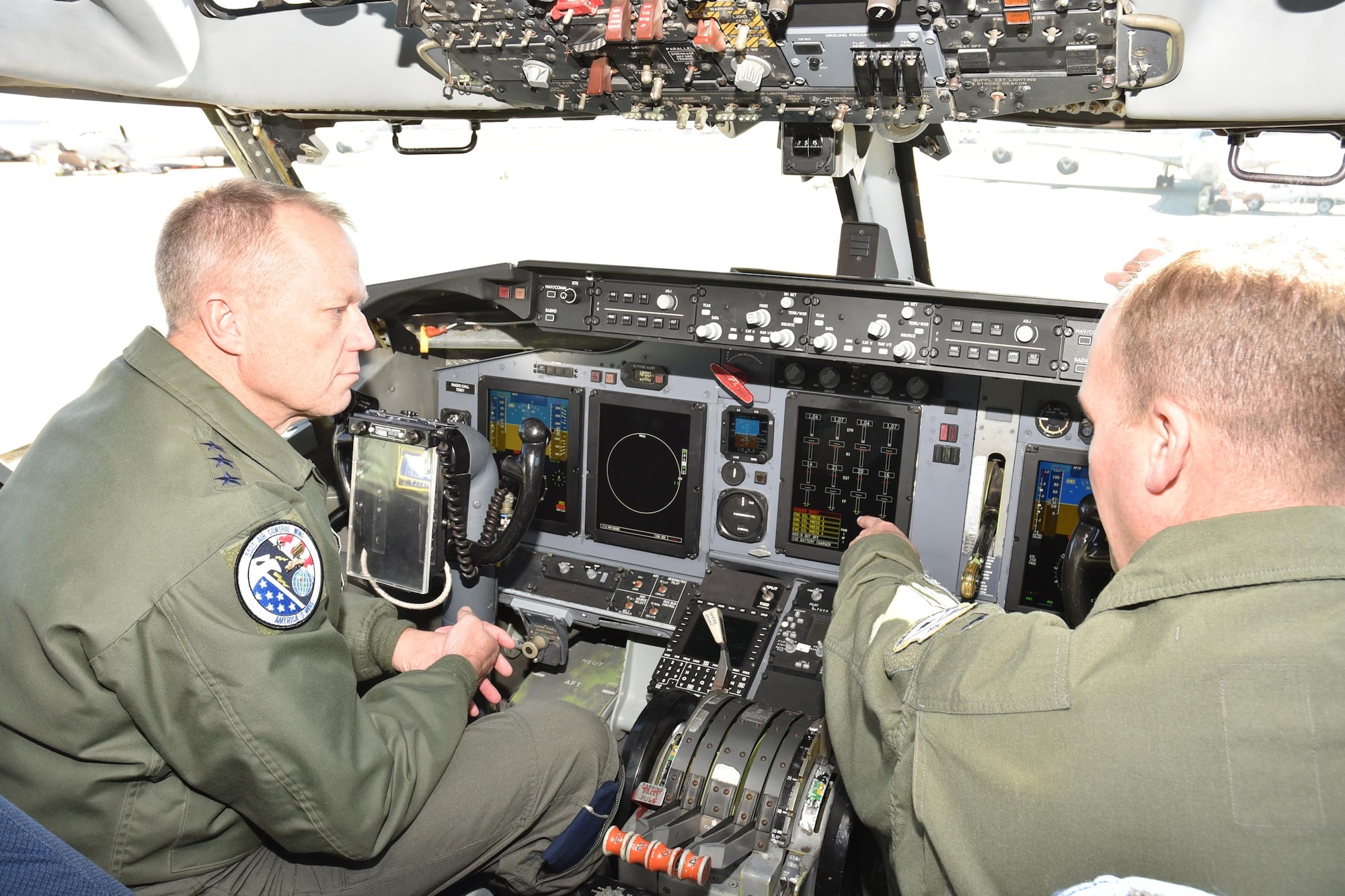 Lt. Col. Chris Hansen, project officer for the DRAGON Glass Cockpit Modification, points out some of the changes to the E-3G Sentry flight deck to Lt. Gen. Mark Kelly, commander, 12th Air Force (Air Forces Southern), during the general’s visit to the 552nd Air Control Wing Feb. 21. (Air Force photo by Ron Mullan)