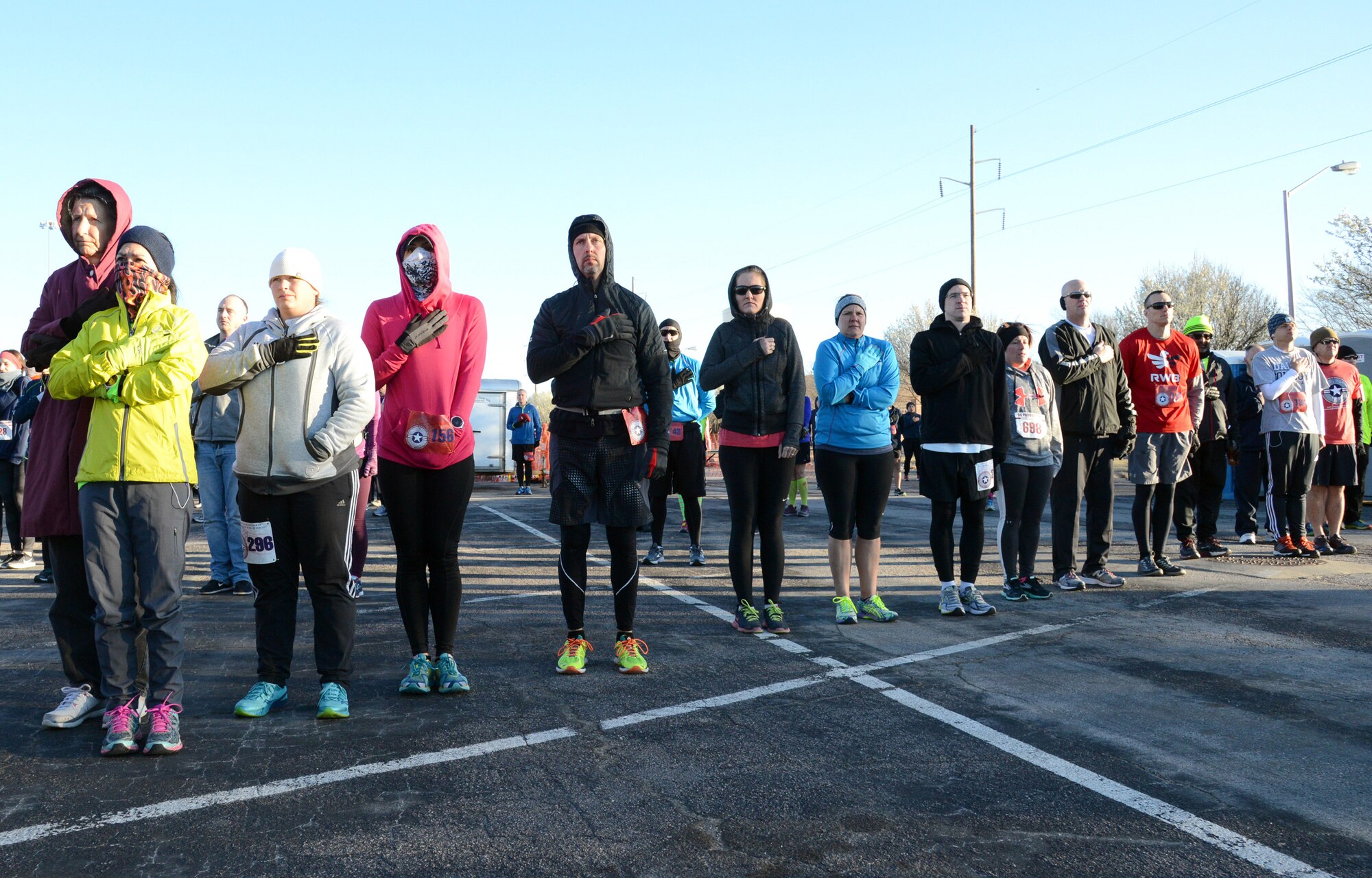 Participants in Tinker’s 75th Anniversary Half Marathon and 5K stand at attention during the playing of the National Anthem before the start of the race. (Air Force photo by Kelly White)