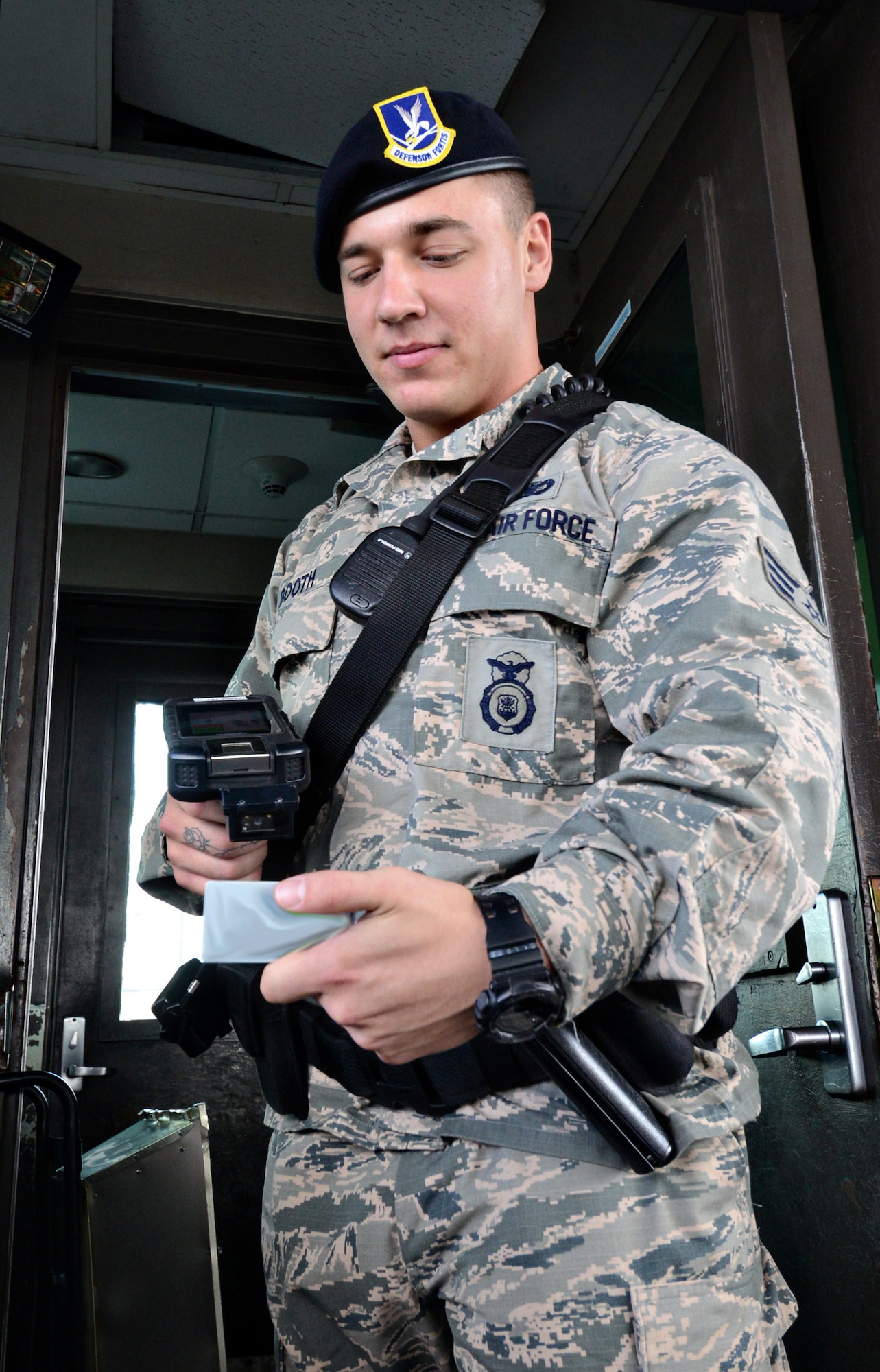Senior Airman Blake Booth, with the 72nd Security Forces Squadron, uses the new Defense Biometrics Identification System while working at the Tinker Gate. (Air Force photo by Kelly White)