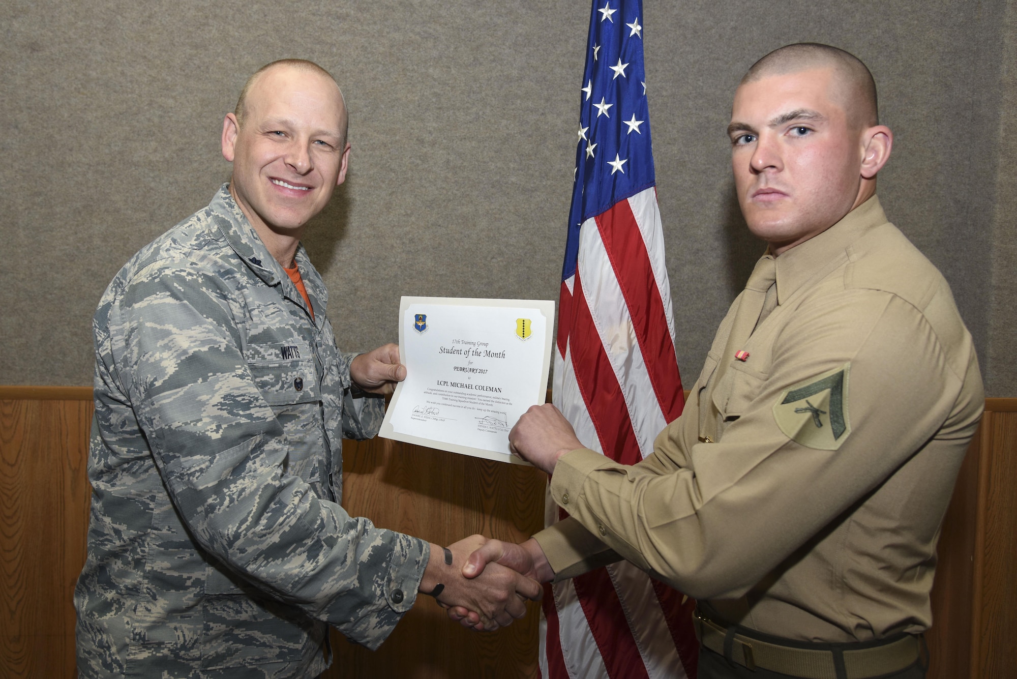 U.S. Air Force Lt. Col. Steven Watts, 17th Training Group deputy commander, presents the 316th Training Squadron Student of the Month award for Febuary 2017 to Lance Cpl. Michael Coleman, 316th TRS student, in the Brandenburg Hall on Goodfellow Air Force Base, Texas, March 3, 2017. (U.S. Air Force photo by Airman 1st Class Chase Sousa/Released)