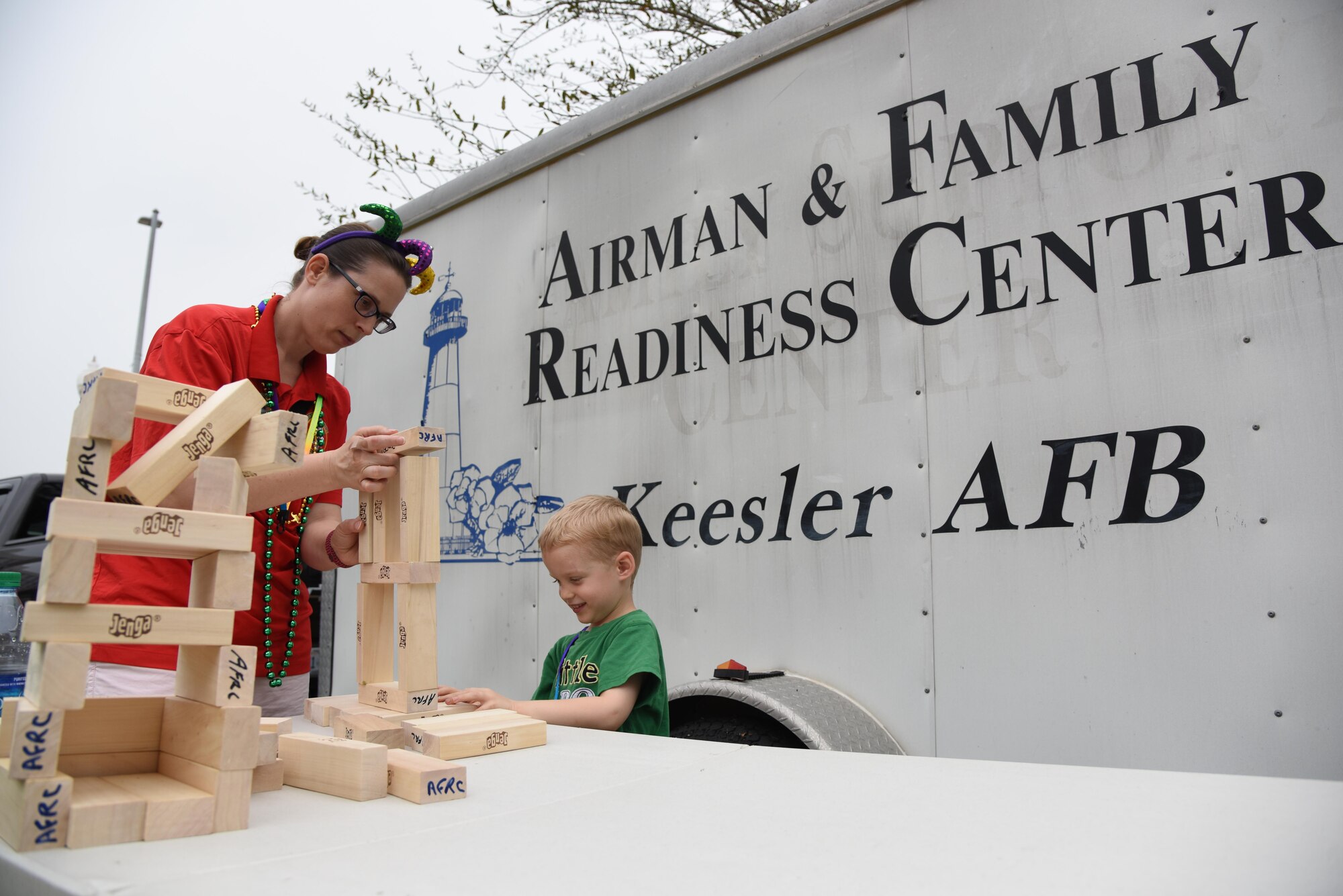 Alicia and Fox Cleary, family of Tech. Sgt. Richard Cleary, 336th Training Squadron instructor, play with building blocks during the Gulf Coast Carnival Association Mardi Gras parade Feb. 28, 2017, in Biloxi, Miss. The 81st Force Support Squadron’s Airman and Family Readiness Center staff invited families of deployed members to the event and provided food and entertainment to them prior to the start of the parade. Alicia is a 336th TRS key spouse. (U.S. Air Force photo by Kemberly Groue)