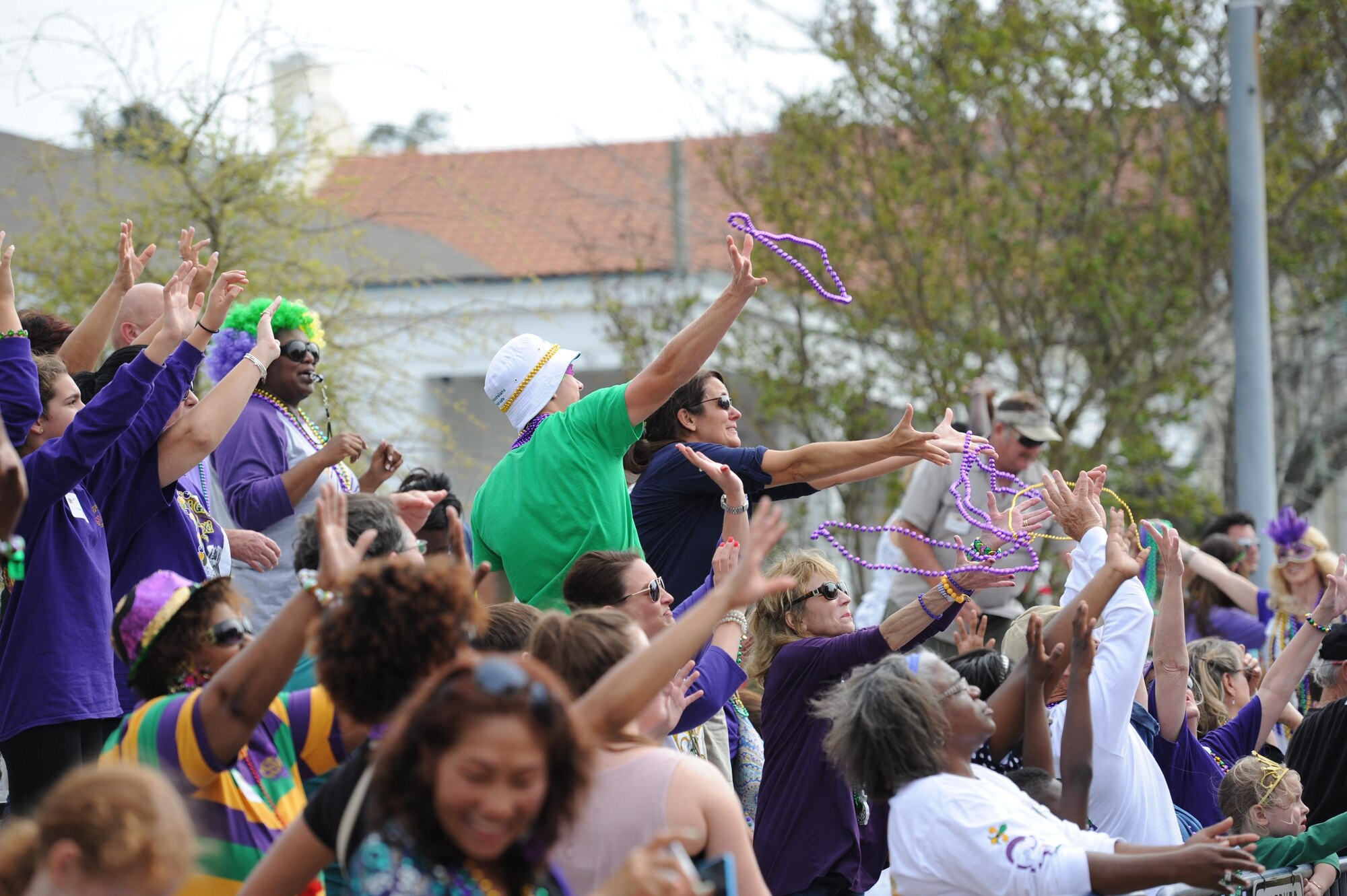 Kristi and Mac Smith, family of Col. C. Mike Smith, 81st Training Wing vice commander, catch beads during the Gulf Coast Carnival Association Mardi Gras parade Feb. 28, 2017, in Biloxi, Miss. Every Mardi Gras season, Keesler personnel participate in local parades to show their support of the communities surrounding the installation. (U.S. Air Force photo by Kemberly Groue)