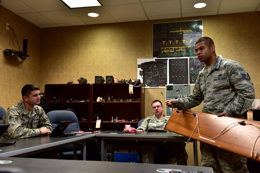 U.S. Air Force Tech. Sgt. Jose Piedra, standing, 373rd Training Squadron Detachment 4 production supervisor and instructor, discusses the importance of the 1553B databus backbone cable for the C-130J to his students Feb. 23, 2017 at the Center of Excellence on Little Rock Air Force Base, Ark.  The cable transfers critical information between the computer systems throughout the aircraft and the Airmen are responsible for the understanding how they work. (U.S. Air Force photo by Staff Sgt. Jeremy McGuffin)