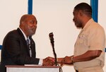 DAHLGREN, Va. - Capt. Godfrey "Gus" Weekes, Naval Surface Warfare Center Dahlgren Division (NSWCDD) commanding officer, presents the Dahlgren history book, "The Sound of Freedom," to Dr. Jeremiah Williams - President of the 100 Black Men of America Inc., Virginia Peninsula Chapter - at the 2017 African American and Black History Month Observance, Feb. 28. “I didn’t realize how smart I was until I joined the Navy," said Williams. "The recruiter told me I qualified for every program the Navy offers. When I went to nuke (Nuclear Power) school, and among the last ones standing, I felt I could conquer the world. The Navy saved me and I appreciated that.”  (U.S. Navy Photo by George Smith/Released)