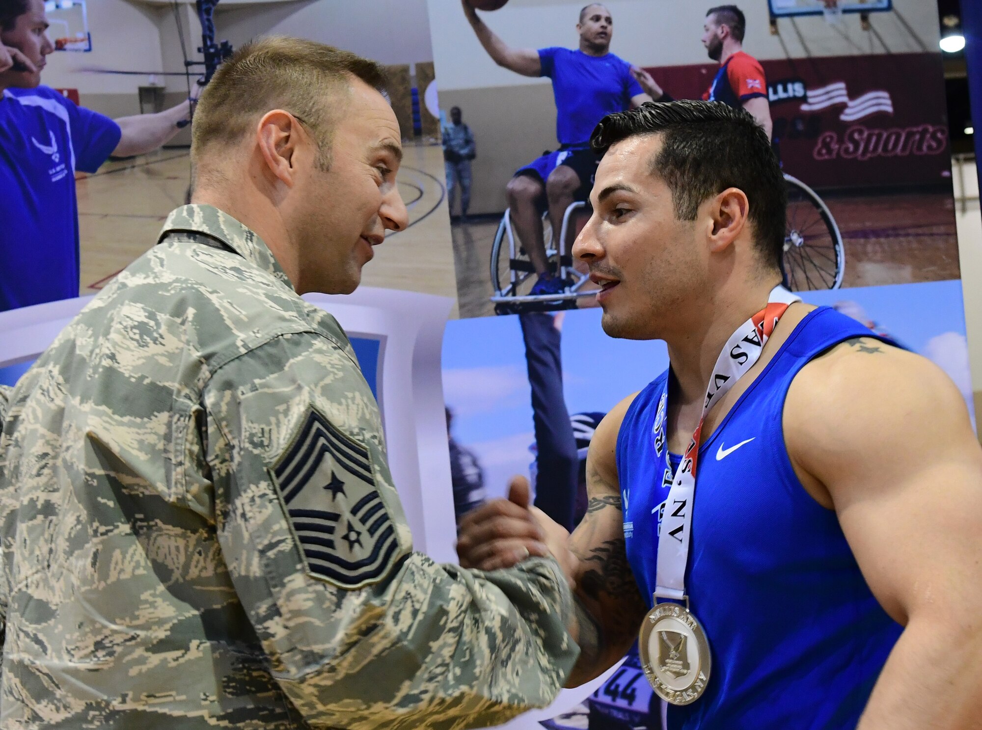 Chief Master Sgt. Jamie 432nd Wing/432 Air Expeditionary Wing command chief, presents a medal to an Air Force Wounded Warrior Trials competitor after competing in the wheelchair basketball competition March 1, 2017, at Nellis Air Force Base, Nev. AFW2 aims to bring wounded warriors together to compete in sports once again and encourage camaraderie while helping them through the recovery process. (U.S. Air Force photo by Senior Airman Christian Clausen)