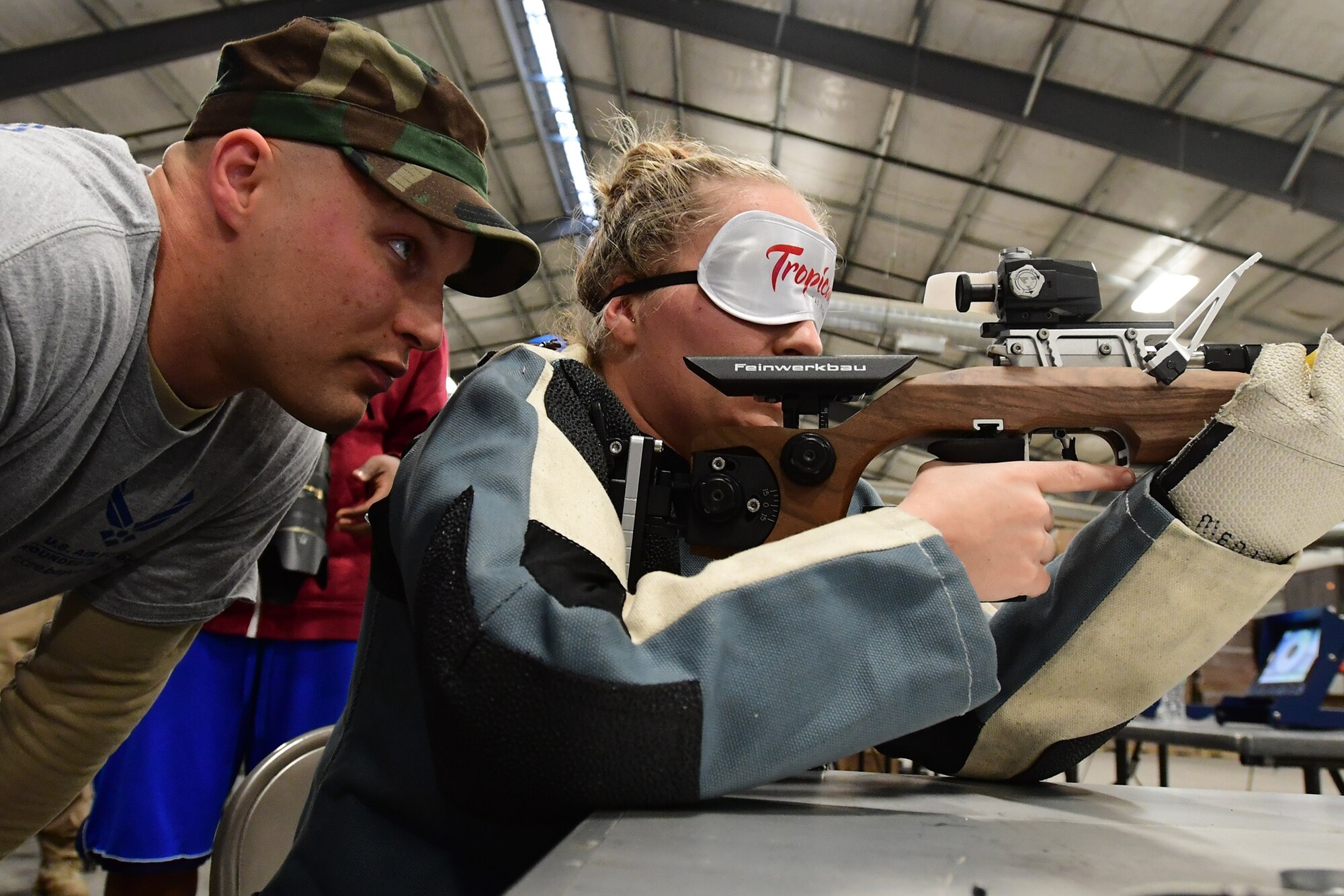 A spotter helps an Air Force Wounded Warrior Trials competitor participate in the shooting competition March 1, 2017, at Nellis Air Force Base, Nev. Some participants competed in a new visually impaired category where a spotter assists the shooter. (U.S. Air Force photo by Senior Airman Christian Clausen)