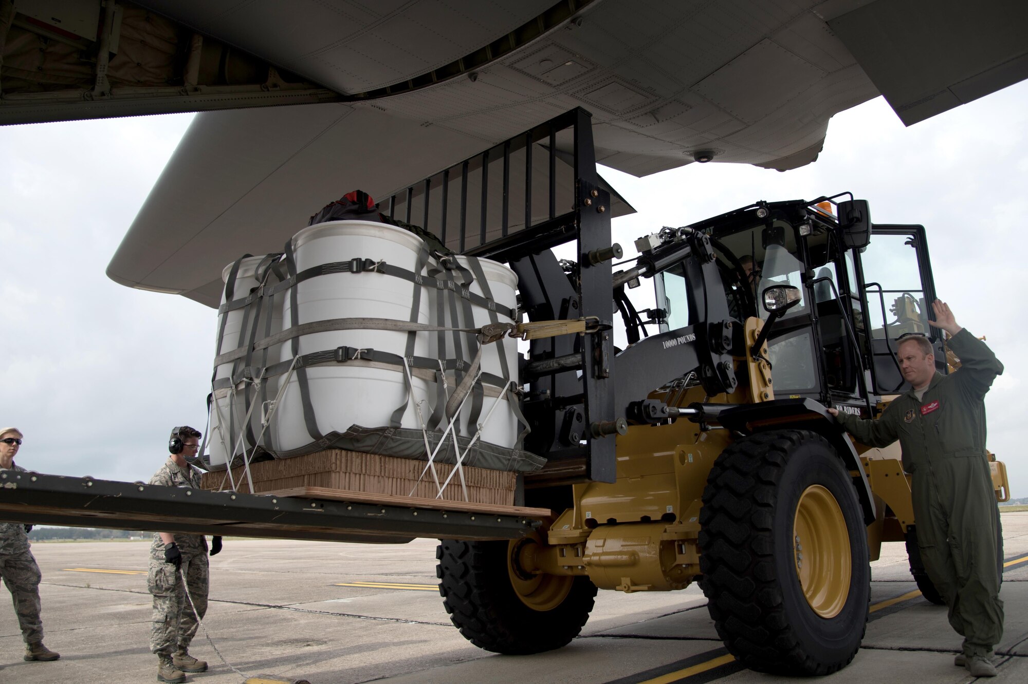 Senior Master Sgt. Darren Bannister, a loadmaster with the 815th Airlift Squadron, marshals a forklift to load a Container Delivery System bundle for an airdrop training mission here, Sunday. These missions help to prepare crews for real world resupply missions all over the world. (U.S. Air Force Photo/ Staff Sgt. Nicholas Monteleone)