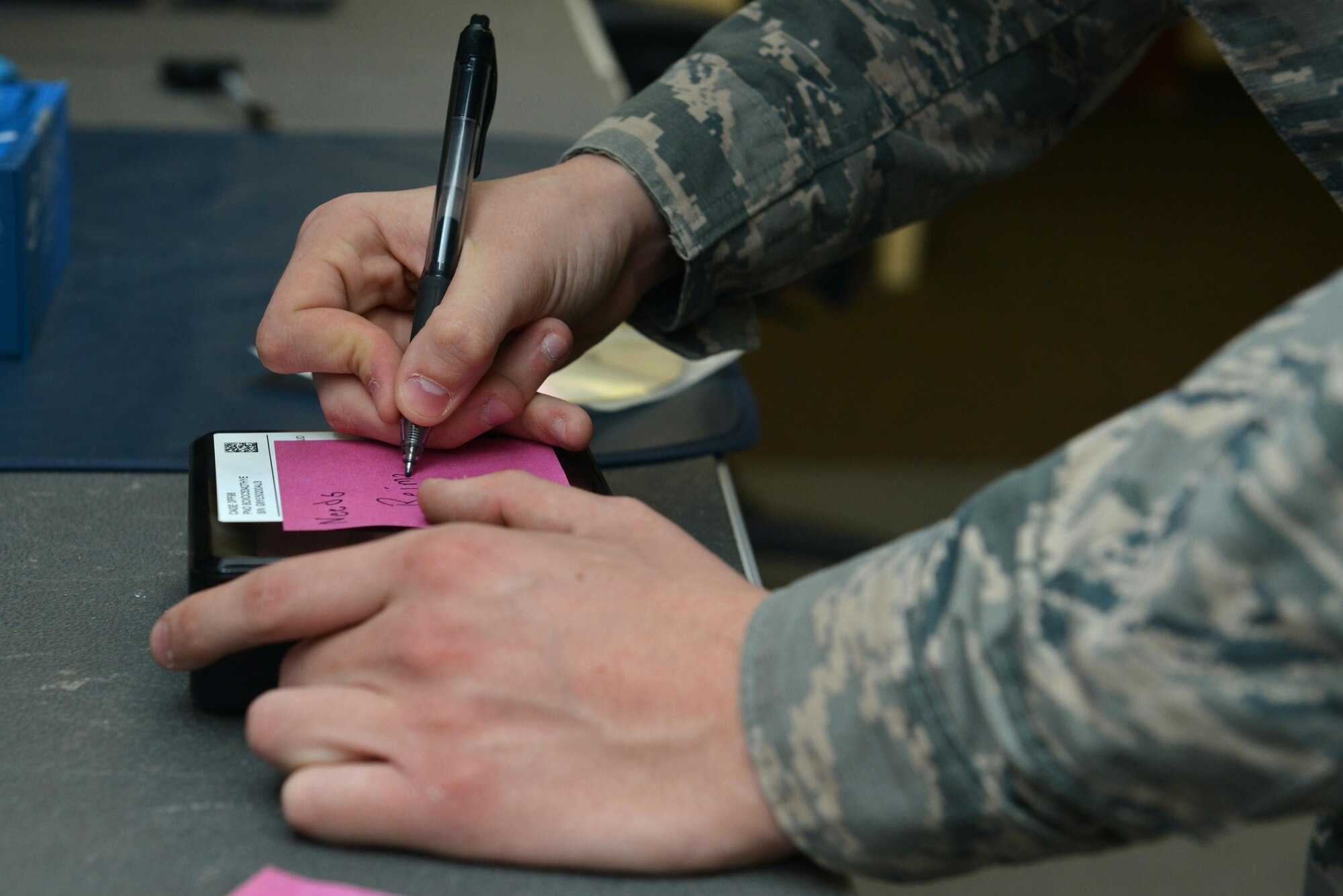 U.S. Air Force Airman 1st Class Hunter Pendry, 20th Communications Squadron client systems technician, writes “needs reimaging” on a sticky note at Shaw Air Force Base, S.C., March 2, 2017. Pendry put the sticky note onto a mini-PC after testing it to determine if it needed its operating system to be reinstalled. (U.S. Air Force photo by Airman 1st Class Destinee Sweeney)