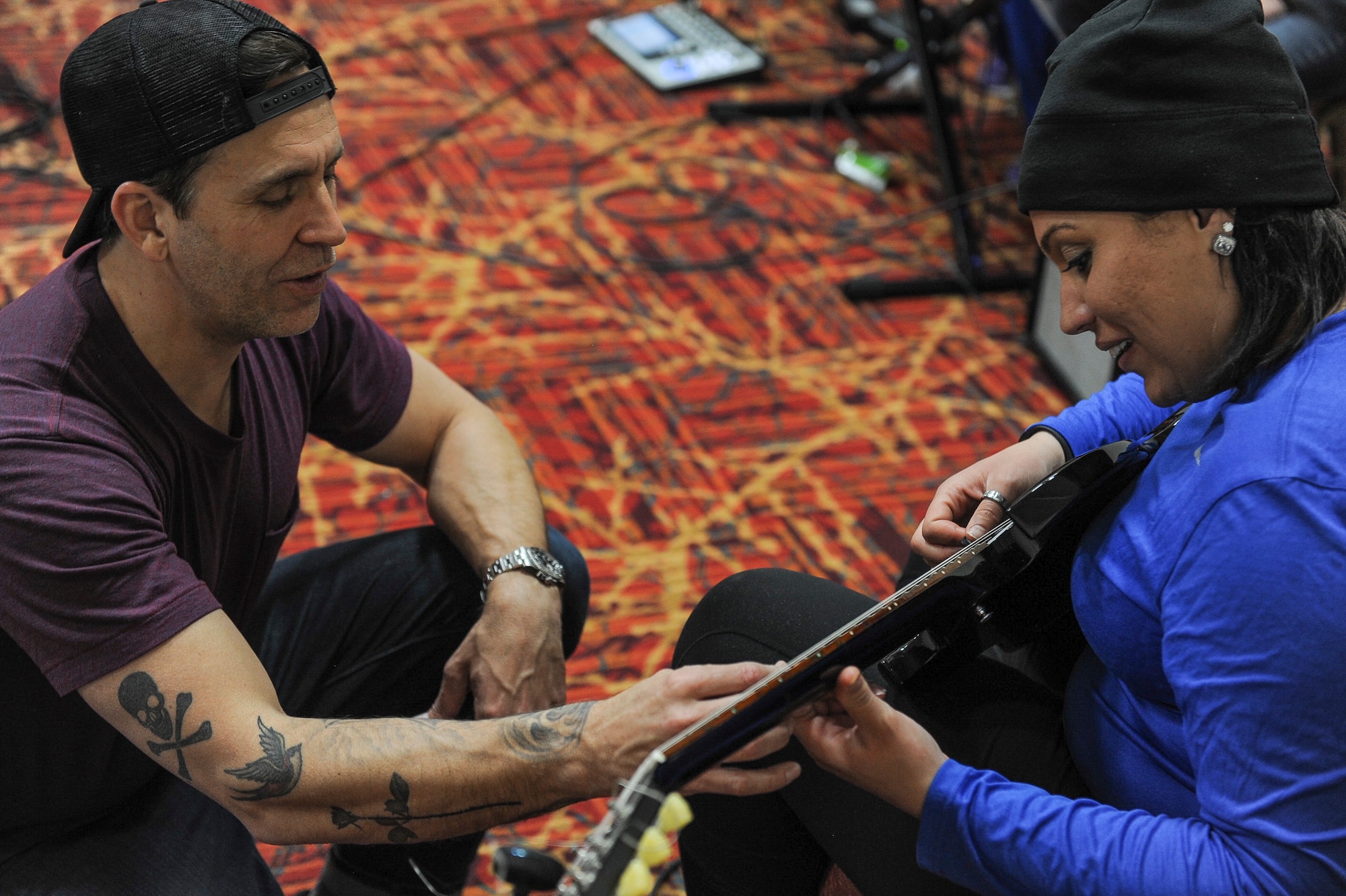 Former Korn guitarist and Rock to Recovery founder Wes Geer gives pointers to an Air Force Wounded Warrior Trials participant during a Rock to Recovery practice session in Las Vegas, March 1, 2015. Rock to Recovery brings together people suffering from similar ailments and each participant shares their personal story before choosing from a variety of instruments to play as part of a band. (U.S. Air Force photo by Staff Sgt. Siuta B. Ika)