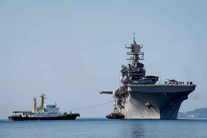 Tugboats guide amphibious assault ship USS Bonhomme Richard (LHD 6) as it arrives at White Beach Naval Facility for a scheduled port visit, Mar. 4, 2017. Bonhomme Richard is on a routine patrol, operating in the Indo-Asia-Pacific region to serve as a forward-capability for any type of contingency. 