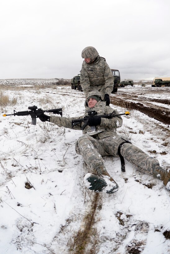 Airman 1st Class Zachary Blackwood, 729th Air Control Squadron, returns fire as he is dragged to cover by Staff Sgt. Ty Craiglow, 729th Air Control Squadron, while practicing in a site defense scenario during an expeditionary training exercise at Hill Air Force Base’s ‘North 40’ training area Feb. 23. (U.S. Air Force photo by Todd Cromar)