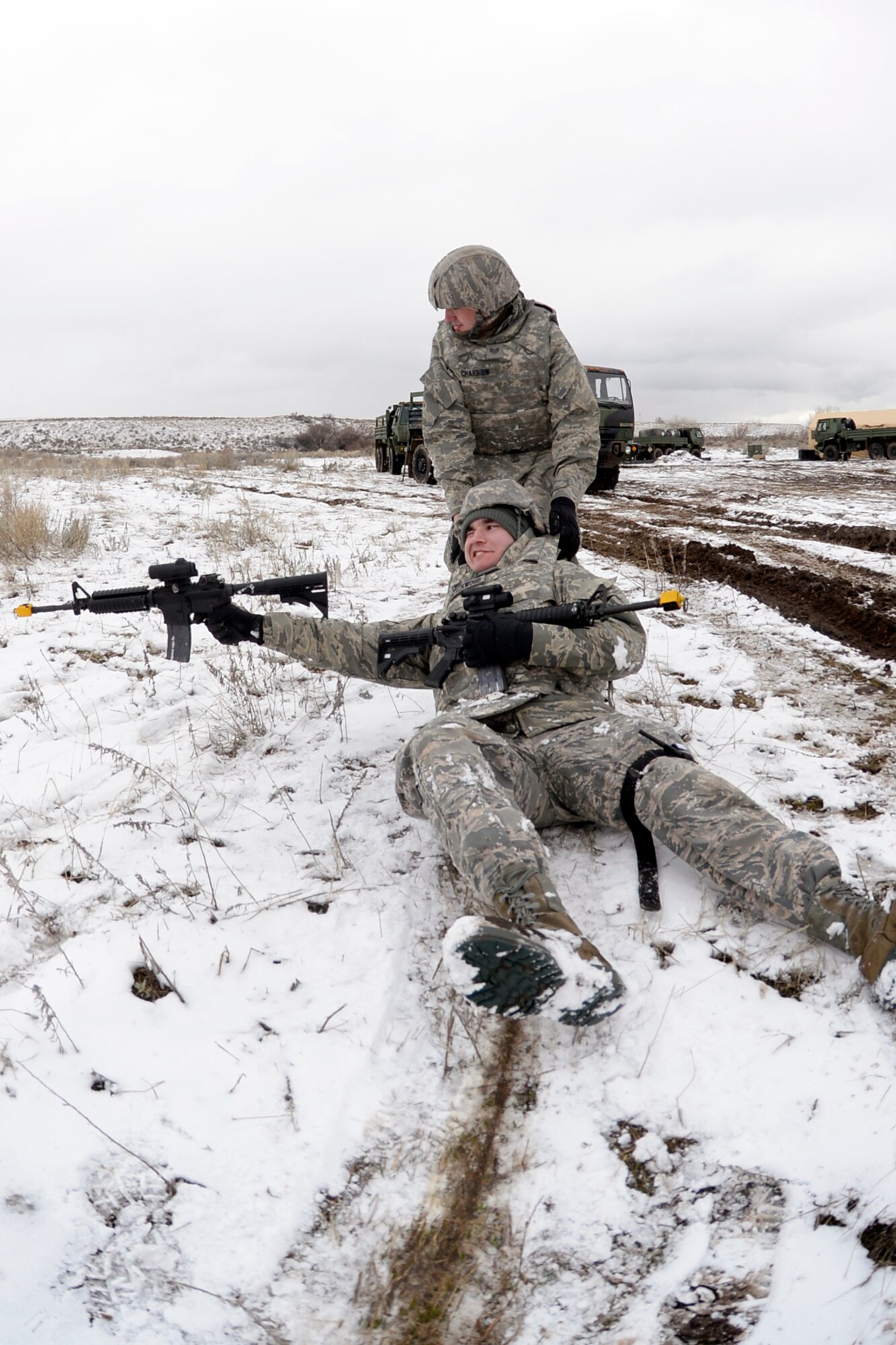 Airman 1st Class Zachary Blackwood, 729th Air Control Squadron, returns fire as he is dragged to cover by Staff Sgt. Ty Craiglow, 729th Air Control Squadron, while practicing in a site defense scenario during an expeditionary training exercise at Hill Air Force Base’s ‘North 40’ training area Feb. 23. (U.S. Air Force photo by Todd Cromar)