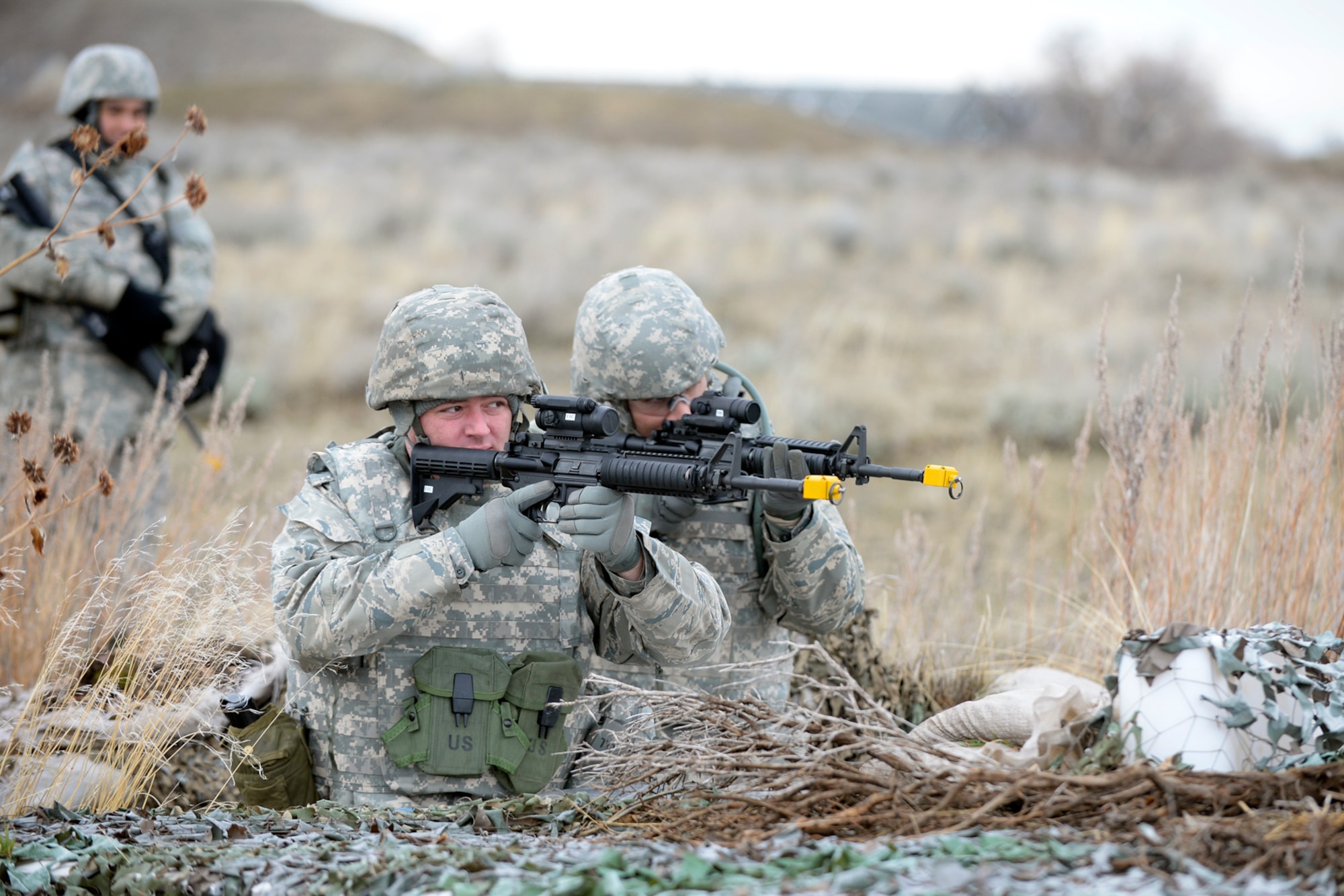 Tech. Sgts. Vincent Bourgeois and Michael Curtin, 729th Air Control Squadron, practice site perimeter defense during expeditionary training Feb. 22 at Hill Air Force Base. The four-day pre-deployment exercise covered personal preparation, site preparation and defense, weapons familiarization, self-defense, care-under-fire, improvised explosive device classification and communication. (U.S. Air Force photo by Todd Cromar)